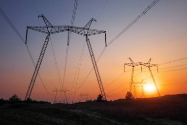 Ateşli gündoğumu sırasında yüksek voltajlı elektrik hatları