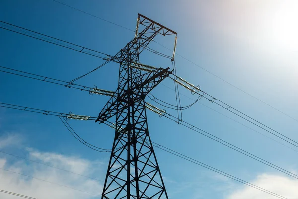 A high voltage power pylons against blue cloudy sky — Stock Photo, Image