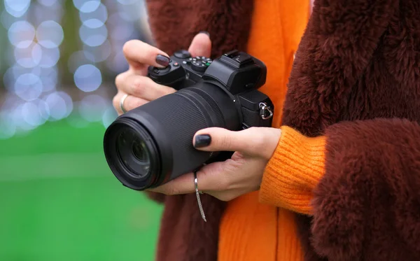 Ragazza blogger con una nuova fotocamera e borsa, scatta foto e video — Foto Stock