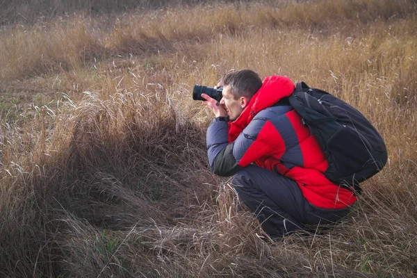 An experienced photographer takes pictures in nature. A professi — Stockfoto