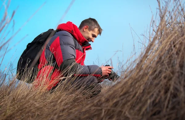 Um fotógrafo experiente tira fotos na natureza. Um professor. — Fotografia de Stock