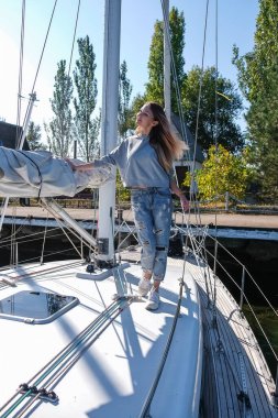 Yatta poz veren güzel bir genç kadın. Modeller gemiye biniyor.