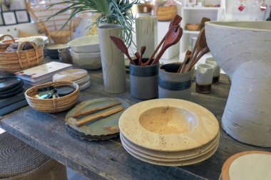 Antika yemekler ve ahşap bir masanın üzerindeki diğer orijinal şeyler. Tabaklar, sepetler, vazolar, kitaplar