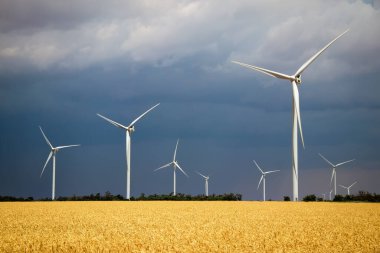 Yaz bulutlu bir günde rüzgâr türbinleri ve tarımsal alanlar. Enerji üretimi, temiz ve yenilenebilir enerji.