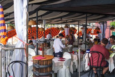  Cinque Terre 'nin en iyi restoranlarından biri olan Belforte' de yemek ve içeceklerden keyif alan insanlar, deniz manzaralı ve ünlü liguryan tarifleriyle tanınıyorlar. Liguria, İtalya. 