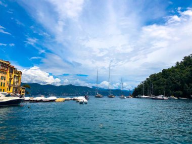 Geniş açılı panorama. İtalyan Rivierası 'nın en güzel sahil kasabalarından biri olan Portofino' nun göz kamaştırıcı manzarası. Yatla dolu liman ve arka planda dağlar Akdeniz manzarası.