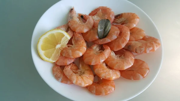 Kitchen and food, cooked shrimp, shrimp in a plate. Boiled shrimp with lemon. roasted prawns on white plate,