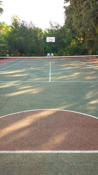 Sport playground for football and basketball, rubber stadium for training. Basketball court covered with red and green rubber crumb with marking