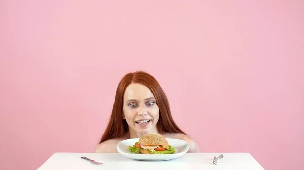 anorexic girl struggles with the temptation to eat a Burger