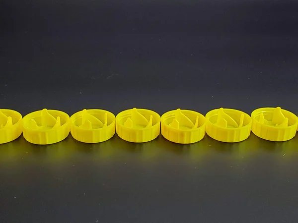 yellow plastic bottle caps isolated on black background