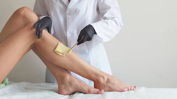 Woman doing foot waxing professional close-up job