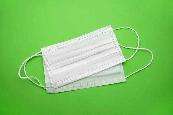 medical disposable face masks isolated on a green background