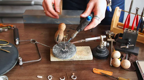 master jeweler works at his workplace in a jewelry workshop. Jewelry making, handmade