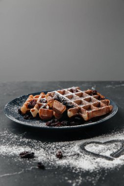 Viennese waffles, sprinkled with powdered sugar, on a dark background,copy space