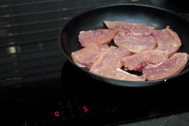 Karabiber serpilmiş domuz parçaları tavada kızartılır, sulu pirzola, akşam yemeği, et.