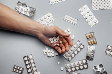 Erkek avucunda yuvarlak beyaz haplar, aşırı doz haplar. Uzayı kopyala Eczane ve tıbbi konsept