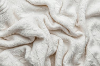 Beyaz yün örülmüş kumaş dokusu. Kumaşın kırışık arkaplanı.