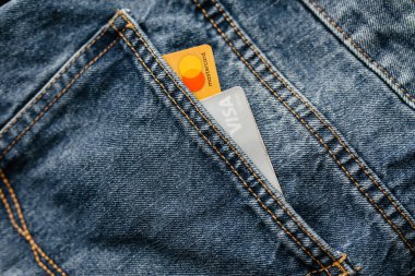 Usinsk, Russia-March 11, 2020: Visa and Mastercard credit cards stick out of your jeans pocket