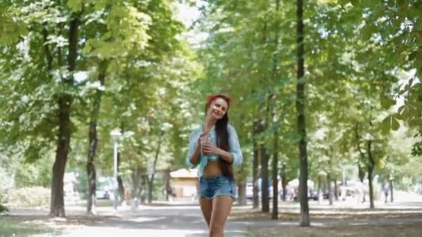 Jonge vrouw wandelen in het park. Amerikaanse stijl. — Stockvideo