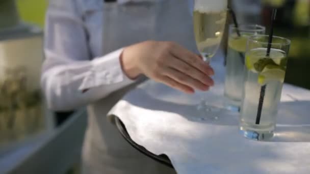 Σερβιτόρος σε ένα λευκό πουκάμισο φέρνει λεμονάδα και σαμπάνια — Αρχείο Βίντεο