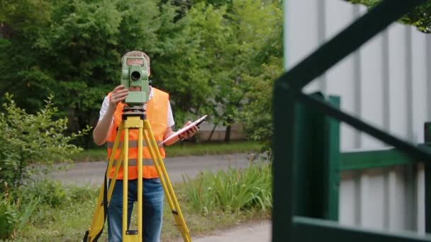 Surveyor på jobbet mäta avstånd — Stockvideo