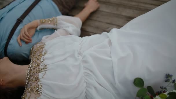 Ženich a nevěsta ležel na dřevěném molu — Stock video