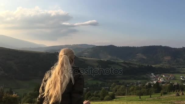 Junge Frau mit blonden Haaren springt an die Spitze — Stockvideo