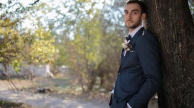 Damat portresi. Genç adamın ağacın yanına.