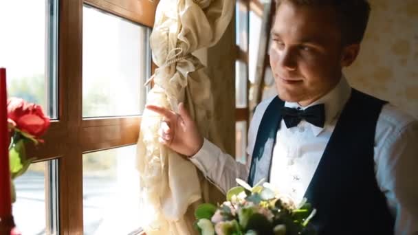 Bruidegom kijken naar het venster — Stockvideo