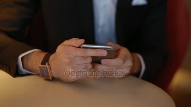 Młody człowiek w garniturze przy użyciu smartfona — Wideo stockowe