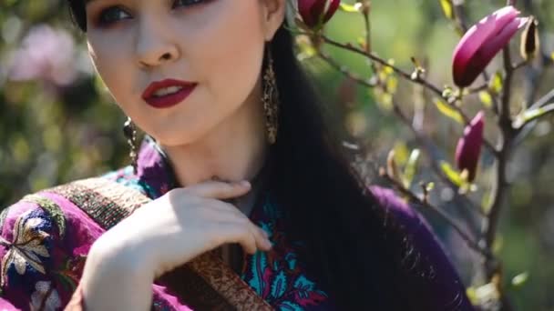 Joven asiática pose en flor magnolia — Vídeos de Stock