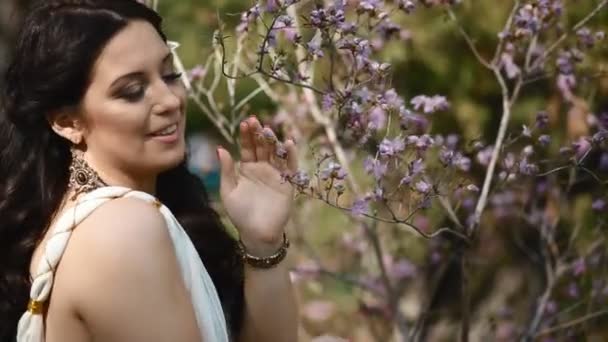 Jovem mulher de vestido branco no parque da primavera — Vídeo de Stock