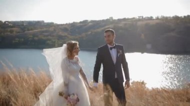 Gelin ve damat nehir kenarında yürüyüş