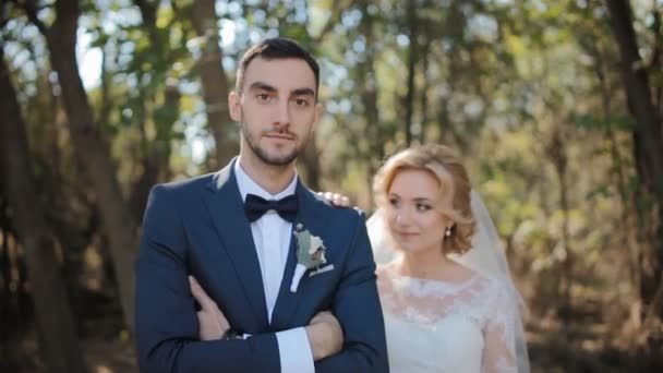 Bruid en bruidegom poseren buiten — Stockvideo