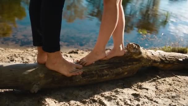 Young couple stand on the log and kiss each other — Stock Video