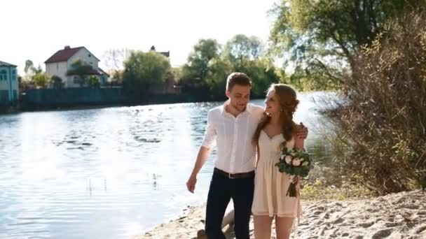Braut und Bräutigam spazieren am Strand — Stockvideo