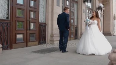 Gelin ve damat dışarıda poz veriyorlar.