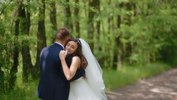 Bruid en bruidegom pose in het bos — Stockvideo
