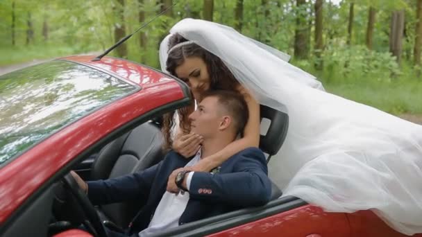 Bruid en bruidegom in rode cabriolet — Stockvideo