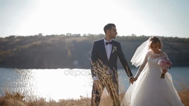 Sposa e sposo a piedi vicino al fiume — Video Stock