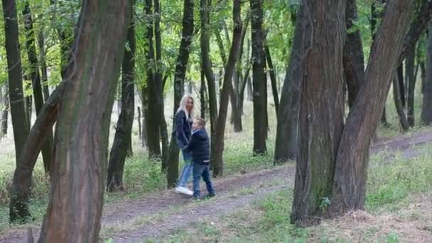 Moeder en zoon wandelen in het park — Stockvideo