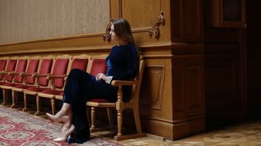 Tiyatroda bekleyen kadife elbiseli genç kız