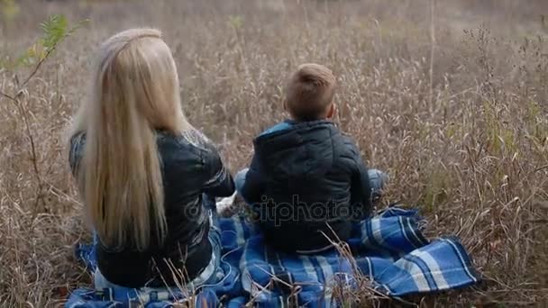 Mère et fils assis sur le plaid en plein air — Video