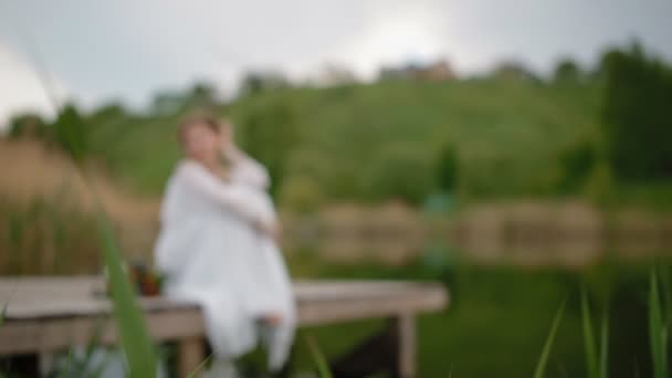 Jeune femme assise sur la jetée en bois — Video