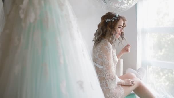 Bruid in lace neglige in de buurt van het venster — Stockvideo