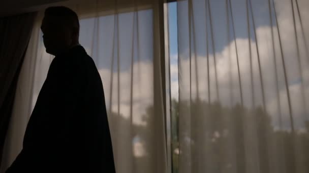 Ο άνθρωπος στο κοστούμι με τα πόδια μπροστά από το μεγάλο παράθυρο — Αρχείο Βίντεο