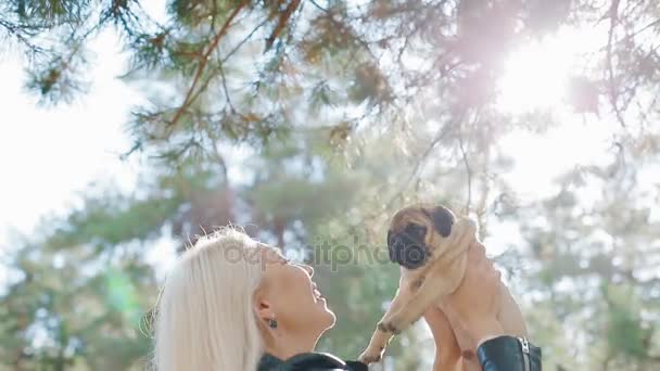 Blanke vrouw gooien up de pug puppy — Stockvideo