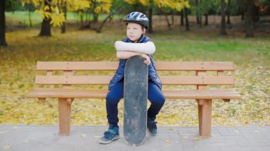 Kırık kolu ile paten oturan beyaz çocuk