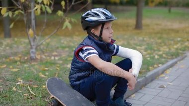 Beyaz çocuk onun paten ile sınır oturan