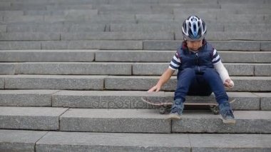 Kırık kol ile sıkılmış beyaz çocuk